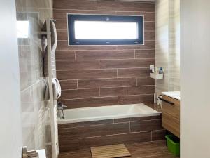 a bathroom with a tub and a tv on the wall at Villa californienne à 10 minutes à pied du centre-ville in Vence