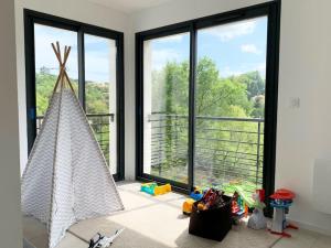 a room with large windows and toys in front of them at Villa californienne à 10 minutes à pied du centre-ville in Vence