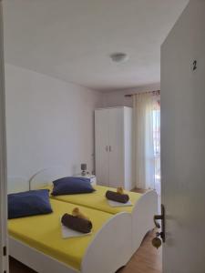 a bedroom with a large yellow bed with blue pillows at APARTMANI ALEN in Dinjiška
