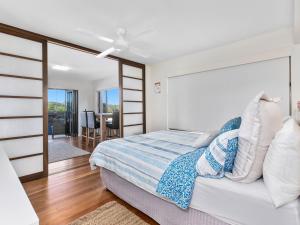 a bedroom with a bed and a ceiling fan at Sunset Waters Creekfront Apartment in Kingscliff