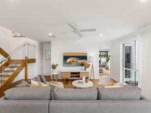 a living room with a couch and a table at Sunrise Mansion with Pool in Kingscliff