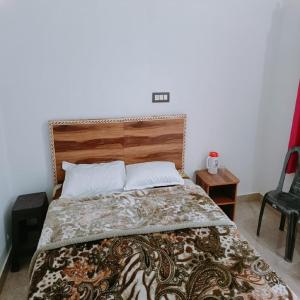 a bedroom with a large bed with a wooden headboard at An Himalayan View by StayApart in Barkot