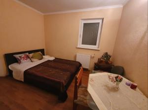 a bedroom with a bed and a table at Diana center Hotel with Grill zone and yard in Chişinău