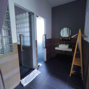 uma casa de banho com um chuveiro, um lavatório e um espelho. em GOLDEN LOTUS SPA & HOMESTAY em Ấp Thiện Phước