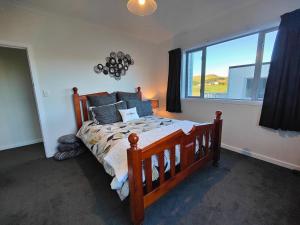 a bedroom with a wooden bed and a large window at Church Street Charmer in Riverton