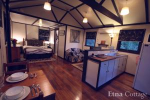 a room with a kitchen and a room with a bed at Tudor Cottages in Mount Dandenong