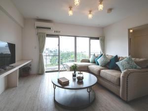 a living room with a couch and a table at Cozy Stay in Naha in Naha