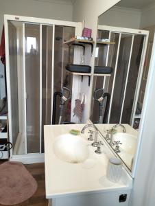 een badkamer met een witte wastafel en een spiegel bij Bungalow Cosystay in Meadow Heights