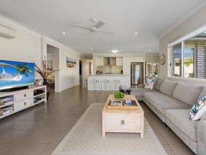 a living room with a couch and a tv at Salty Pause at Bondi House - Pet Friendly! in Kingscliff