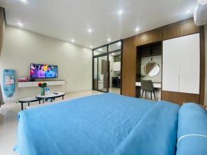 een slaapkamer met een blauw bed en een woonkamer bij MetaHome SAKURA Apartment & Homestay -193 Văn Cao in Hai Phong