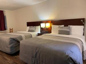 Habitación de hotel con 2 camas y 2 lámparas en Travelers Beach Inn, en Ventura