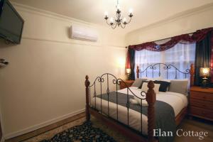 um quarto com uma cama e um lustre em Tudor Cottages em Mount Dandenong