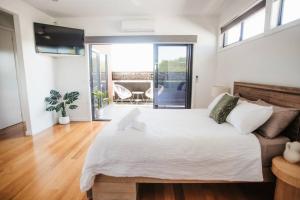 a bedroom with a large bed and a balcony at Loft On Bridge in Benalla