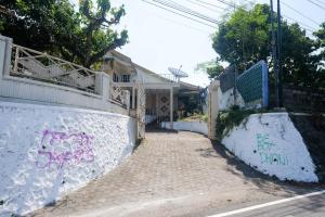una casa con graffiti al lado de una pared en My Cafe Hotel near UGM Yogyakarta Mitra RedDoorz, en Kejayan