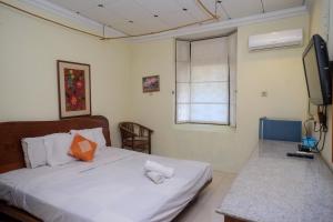 a bedroom with a bed and a television in it at My Cafe Hotel near UGM Yogyakarta Mitra RedDoorz in Kejayan