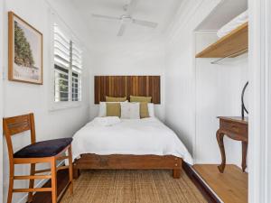 een slaapkamer met een bed, een bureau en een stoel bij Oceanfront Beach House On Marine Parade in Kingscliff