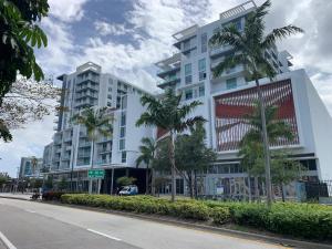 ein Gebäude mit Palmen vor einer Straße in der Unterkunft Luxury Oceanview Studio at Miami Design District in Miami