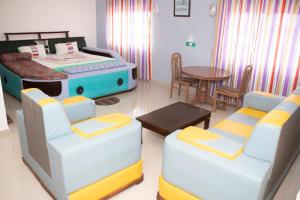 Habitación con cama, mesa y sillas. en Alafia Hotel Ketou, en Kétou