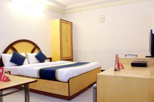 a hotel room with a bed with blue pillows at OYO Hotel Ganga Sagar Near Sri Someshwara Swami Temple in Bangalore