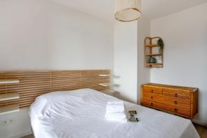 um quarto com uma cama branca e uma cabeceira em madeira em Villa Canoem - Welkeys em Cassis