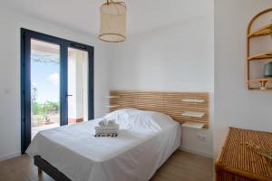 um quarto branco com uma cama e uma janela em Villa Canoem - Welkeys em Cassis