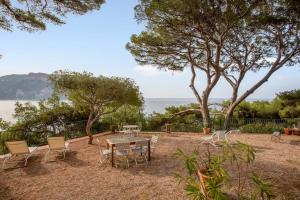 um pátio com uma mesa e cadeiras e o oceano em Villa Canoem - Welkeys em Cassis