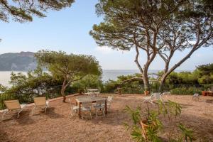 a patio with a table and chairs and the ocean at Villa Canoem - Welkeys in Cassis