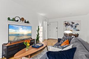 a living room with a gray couch and a large screen tv at Double King Suite with Patio Dining and Parking NRP21-00386 in Long Beach