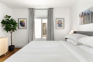 a white bedroom with a large bed and a window at Double King Suite with Patio Dining and Parking NRP21-00386 in Long Beach