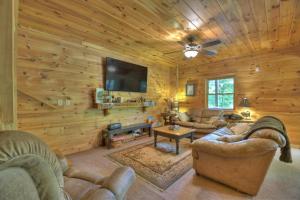 un soggiorno con pareti in legno, TV e divani di Papa Bear Lodge a Blue Ridge