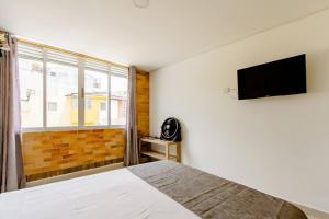 a bedroom with a bed and a flat screen tv at EDIFICIO Niza80 ibague in Ibagué