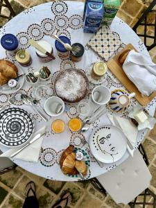 un tavolo bianco ricoperto di piatti e piatti di Le Biadelle - Country Boutique Apartments - Villa Laura Ostuni a Ostuni