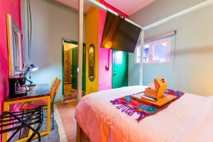 Dormitorio colorido con cama y escritorio en Casa Colibrí Malecón en Puerto Vallarta