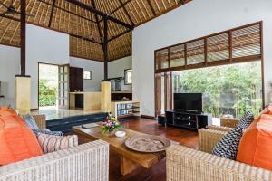sala de estar con muebles de color naranja y TV en Villa Sasoon, 100 mt to Beach en Candidasa