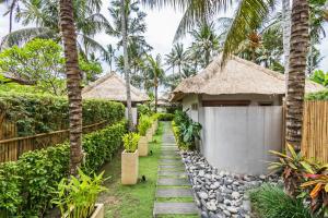 um caminho que leva a uma casa com palmeiras em Villa Sasoon, 100 mt to Beach em Candidasa