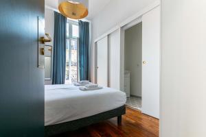 a bedroom with a bed and a large window at Madeleine's Top Rated 8 Traveller City Center Bordeaux Appartments in Bordeaux +19 photos
