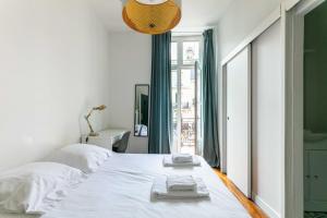 a bedroom with a white bed with towels on it at Madeleine's - Family & Group Apartments in Bordeaux's Historic Centre in Bordeaux +28 photos