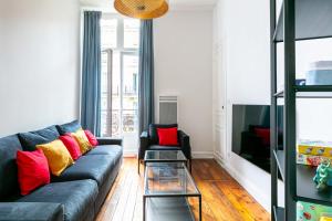 a living room with a blue couch and red and yellow pillows at Madeleine's Top Rated 8 Traveller City Center Bordeaux Appartments in Bordeaux