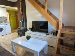 sala de estar con TV y mesa blanca en Bonito y luminoso apartamento con chimenea y wifi - Villanúa, en Villanúa