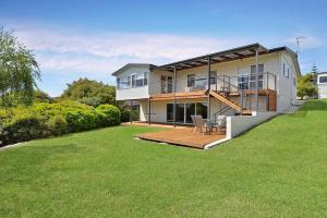 a large house with a deck and a lawn at The BEST Scamander Beach House! in Scamander