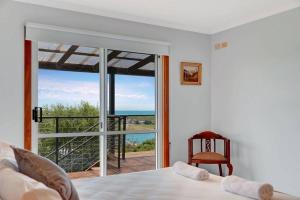 a bedroom with a bed and a view of the ocean at The BEST Scamander Beach House! in Scamander