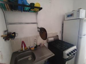 uma pequena cozinha com um lavatório e um fogão em Casa con Alberca en Ixtapa Zihuatanejo Internet em Ixtapa