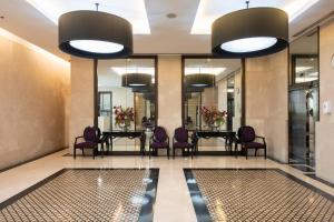 un vestíbulo con una mesa larga y sillas moradas en M Estate 2BR Private Residence, 300m to BTS Chit Lom en Bangkok