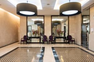 a lobby with a long table and purple chairs at M Estate 2BR Private Residence, 300m to BTS Chit Lom in Bangkok