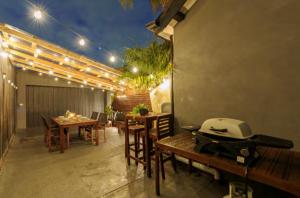un patio con mesa, sillas y luces en Quite, quaint & private guesthouse, sleeps 6, en Melbourne
