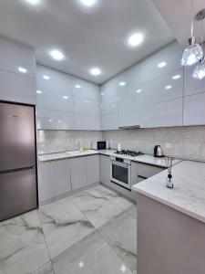 una gran cocina blanca con armarios y electrodomésticos blancos en TZ en Baku