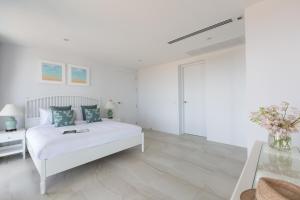 サムイ島にあるCobalt Suite Sea View Apartmentの白いベッドルーム(ベッド1台、テーブル付) +11枚の写真