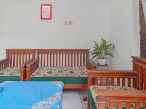 a room with two tables and two chairs and a plant at RedDoorz Syariah near RSUD Karawang 2 in Karawang