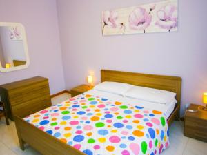 1 dormitorio con 1 cama con un edredón colorido en Appartamento Tintoretto - Agenzia Cocal, en Caorle