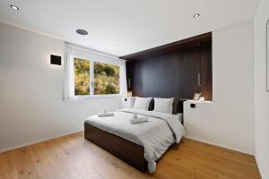 a bedroom with a large bed and a window at The R Apartment Uetliberg, Klima, Parken - Wallbox in Geroldswil